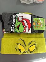 Two pairs TMNT socks stacked on Grinch beanie
