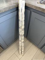 Two full-length sealed rolls leaning against cabinet