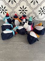Group of nine felt penguin ornaments on surface