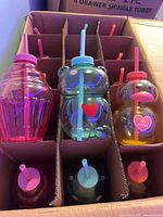 Box of 15 novelty cups separated in cardboard dividers, showing three designs