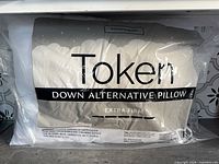 Front of sealed Token pillow showing brand, product line, firmness