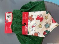 Front view of sweater and bandana with tags