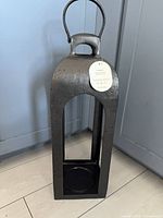 Front view of the black metal lantern showing overall form and size