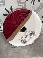 Front view of ribbon roll showing red ribbon and spool