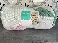 Rolled Pillowfort tulip knit throw blanket showing label and pattern