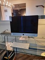 Front view of Apple iMac on glass desk with keyboard