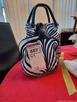 Both art glass purse vases front view with size comparison