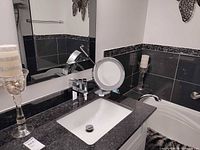 Vanity area showing candle holder, magnifying mirror, butterfly wall decor