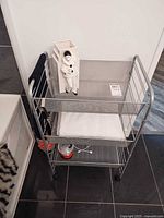 Full view of grey three-tier rolling cart with contents