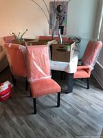 Group view of all six orange upholstered dining chairs around table
