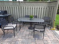 Patio set showing four of the six black wicker outdoor chairs around table
