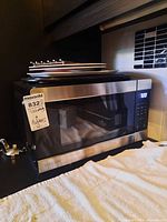 Microwave with stack of plates on top showing front and display