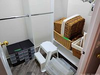 Full closet view showing drawer organizers, step stool, baskets, loose drawers and hangers