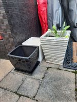 Three square planters: black patterned, light-grey, white ribbed