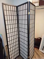Full view of three-panel privacy screen standing partially folded