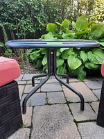 full view of side table showing metal base and glass top