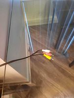 Top view showing clear glass surface and AV cable for scale