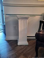Front view of glass top console table showing pedestal base