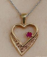 Front view of heart-shaped 10K gold pendant on chain showing pink stone