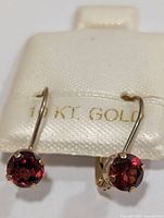 Front view of both gold garnet earrings on display pad