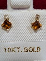 Front view of earrings on card showing square tourmaline stones and accent stones