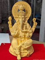 Front view of gold foil Lord Ganesha statue inside acrylic case