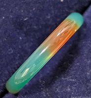 Side view of agate ring showing green and orange gradient