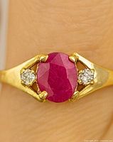 Ring on finger showing ruby and diamonds front view