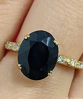 Top view of ring showing oval sapphire and diamond accented band