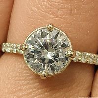 Ring on finger showing center stone and accent stones