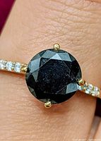 Ring on finger showing black diamond and moissanite accents