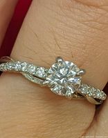 Ring on finger showing center diamond and twisted shank with accents