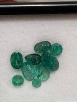 Loose emerald gemstones on white background