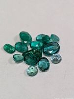 Group of loose emerald stones on white background