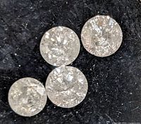 Close-up of four round diamonds showing facets and clarity