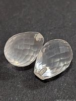 Two faceted rose quartz briolettes on black background