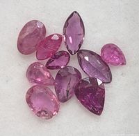 Group of ten loose rubies laid out showing colour and cuts