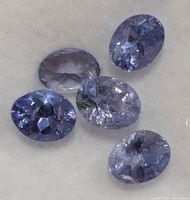 Close-up of five oval tanzanite gemstones showing color and facet clarity
