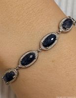Bracelet on wrist showing three sapphire links