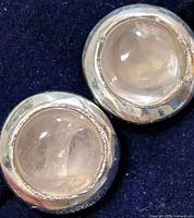 Front view of both stud earrings showing rose quartz cabochons in silver bezel