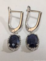 Front view of both silver sapphire earrings showing overall design