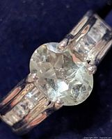 Top view of ring showing oval green amethyst and channel accent stones