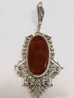 Front view showing silver filigree and red agate cabochon