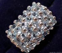 Front view showing cluster of blue topaz stones and silver bead prongs