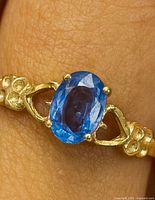 Ring on hand showing sapphire and band detail
