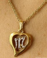 Pendant displayed on chain, showing heart shape and Virgo symbol