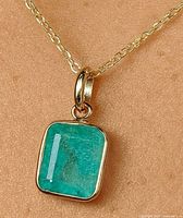 Pendant worn on model showing emerald color and gold bezel