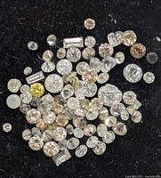 Close-up of assorted loose diamonds on black background