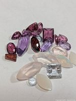 Close-up of assorted faceted and cabochon gemstones showing colours and cuts