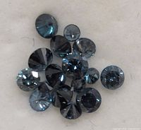 Cluster of blue diamonds on white background showing facets and color